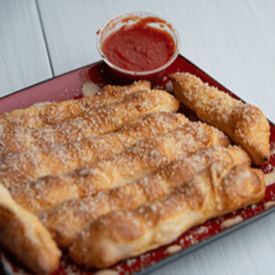 Bacio Pizza's garlic knots, sprinkled with parmesan cheese, served with a side of marinara sauce.